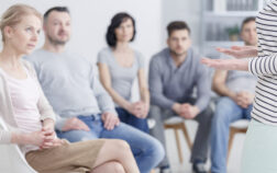 Woman during sharing session Caucasian woman talking to group of people during sharing session