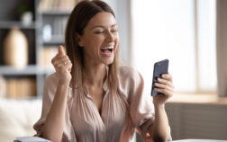 Excited woman looking at phone screen, celebrating online win Excited happy woman looking at phone screen, celebrating online win, overjoyed young female screaming with joy, holding smartphone, reading good news in unexpected message or email